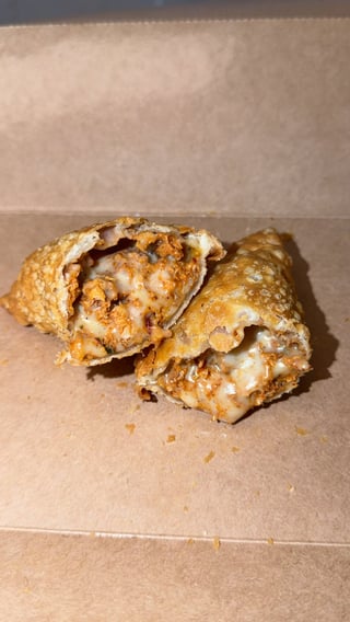 Two golden-brown baked pastries with sesame seeds on parchment paper